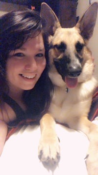 a woman laying on a bed with a dog